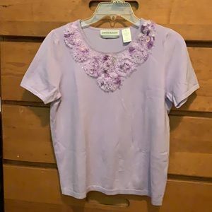 Alfred Dunner lavender shirt sleeve knit top with sequin and cut Pom detailing.